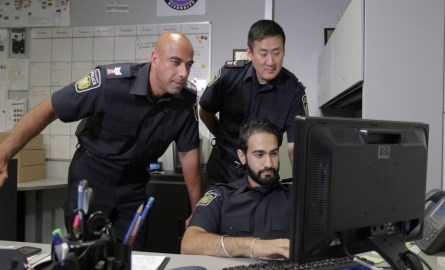 3 Officers looking computer