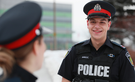 officer speaking to another officer with back facing forward
